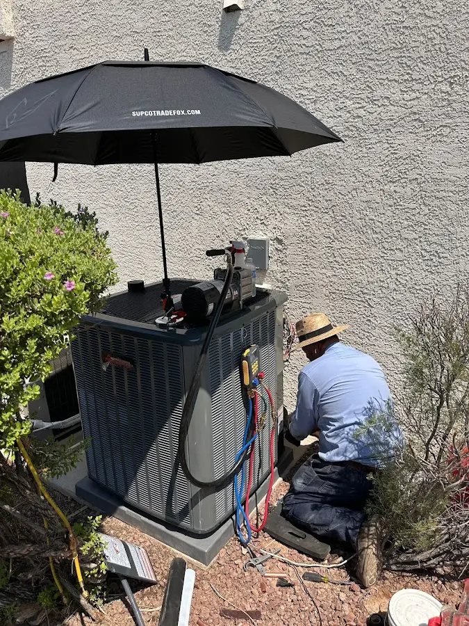 HVAC technician performing outdoor AC maintenance in Ogden