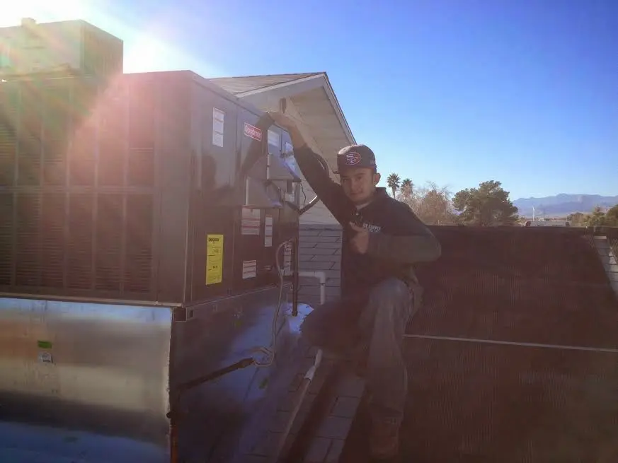 HVAC technician performing Boiler Repair on a rooftop unit in Ogden